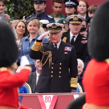 King stands in salute as thousands line streets for VE Day parade
