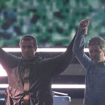 Gallagher brothers share a high-five and hug as Oasis reunite on stage after 16 years